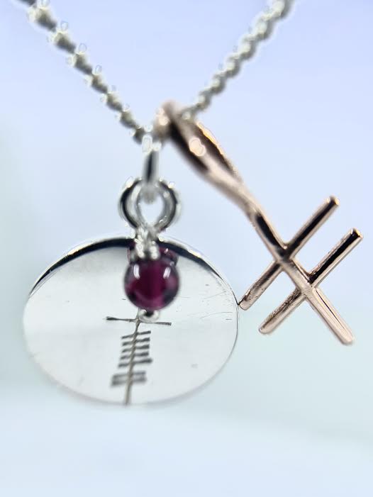 love coin with garnet with gold ogham inital