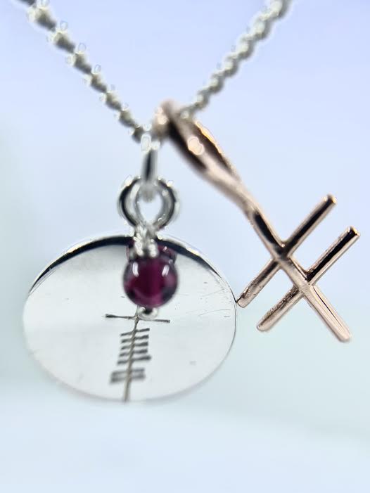 love coin  with garnet with gold ogham inital